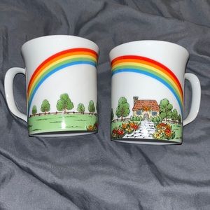 Set of two tea cups rainbow over cottage